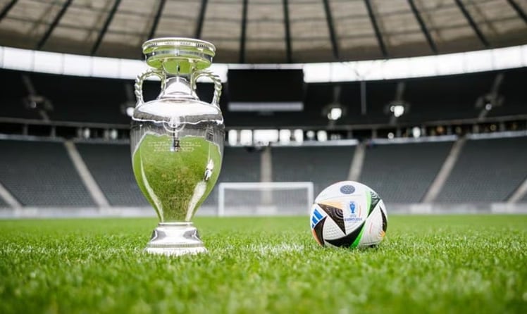 Die begehrte EM-Trophäe neben dem offiziellen Spielball des diesjährigen Turniers von Adidas (Bild: UEFA / Getty Images)