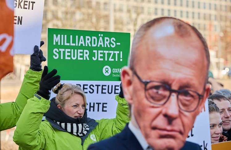 Unter anderem in Begleitung vom überlebensgroßen Pappkanzler setzt sich Oxfam lautstark für eine höhere Versteuerung von Vermögen ein