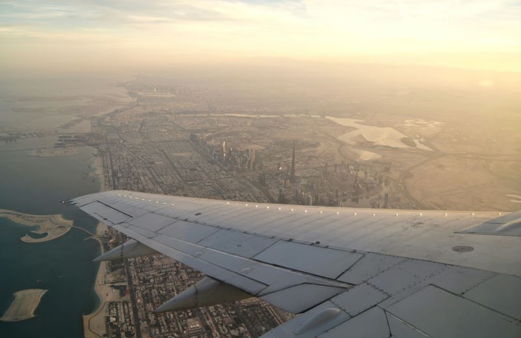 Blick aus einem Flugzeug auf die Skyline von Dubai mit dem Burj Khalifa: Reiseveranstalter reagieren derzeit mit Absagen und Umbuchungen auf die angespannte Lage in der Golfregion.