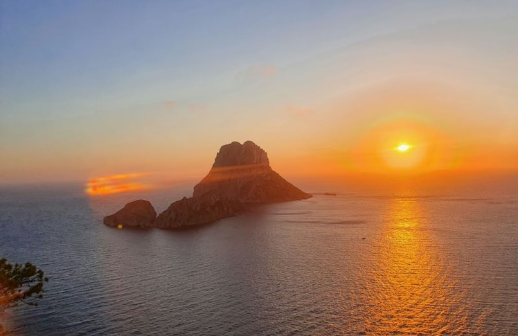 Sonnenuntergang vor Es Vedrà auf Ibiza: Der ikonische Felsen zählt zu den meistfotografierten Sunset-Spots Europas und geht auf Social Media millionenfach viral.