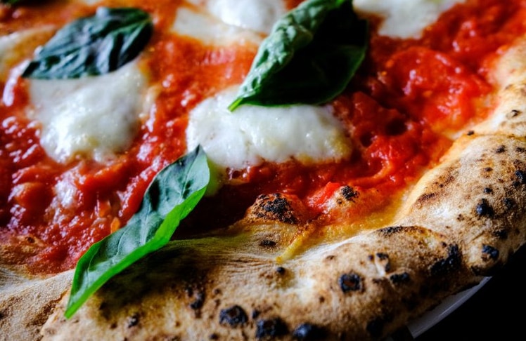 Neapolitanische Pizza gilt als Königsdisziplin der Pizzabäcker. In Neapel gewann Lorenzo Parrotta 2026 als erster Deutscher die Pizza-Weltmeisterschaft.