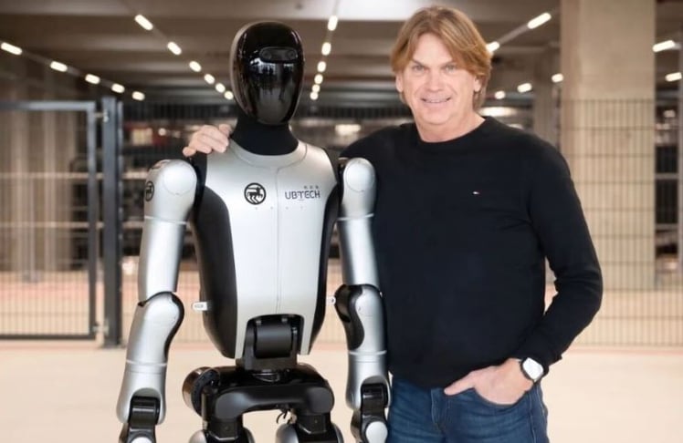 ROSSMANN-Logistikchef Hendrik van Duuren präsentiert den humanoiden Roboter Walker S2, der am Standort Burgwedel im Praxiseinsatz getestet wird.